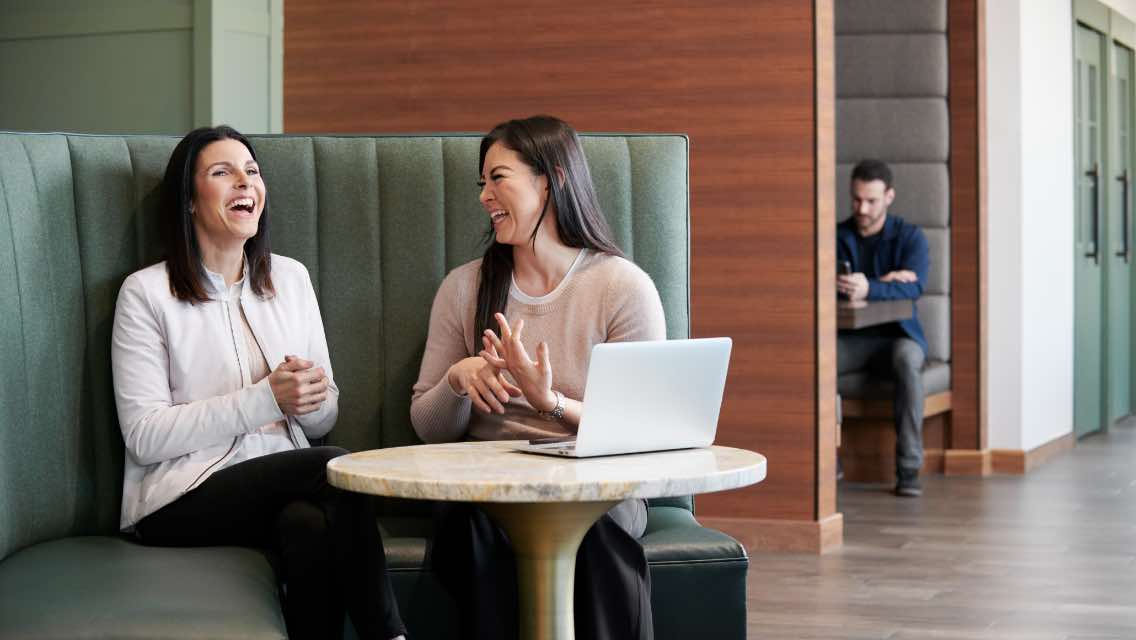 Two women working indoor at a Life Time Work. 