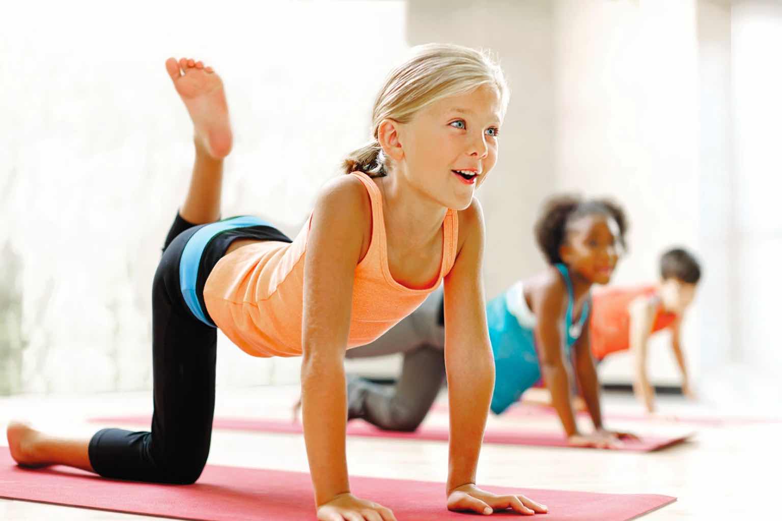 Three kids doing yoga in a Kids Academy class at Life Time