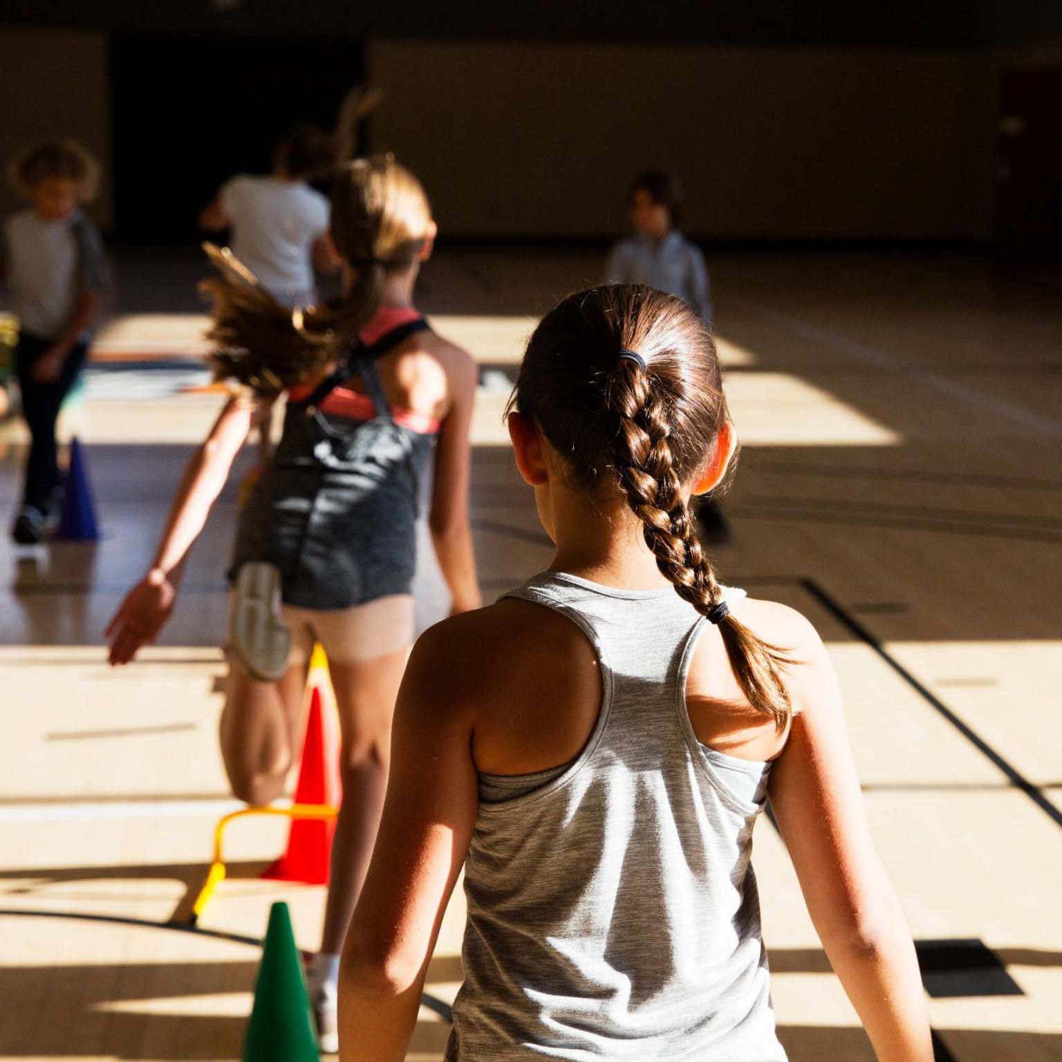 multiple kids playing together in a gym.