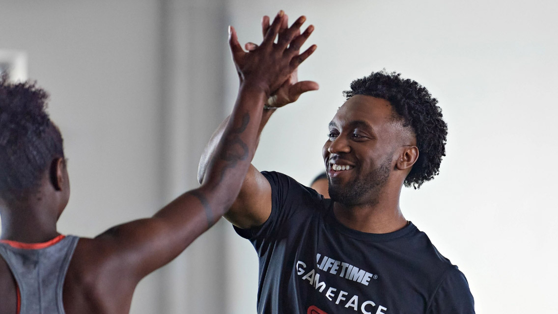 A GameFace coach high-fiving a young athlete