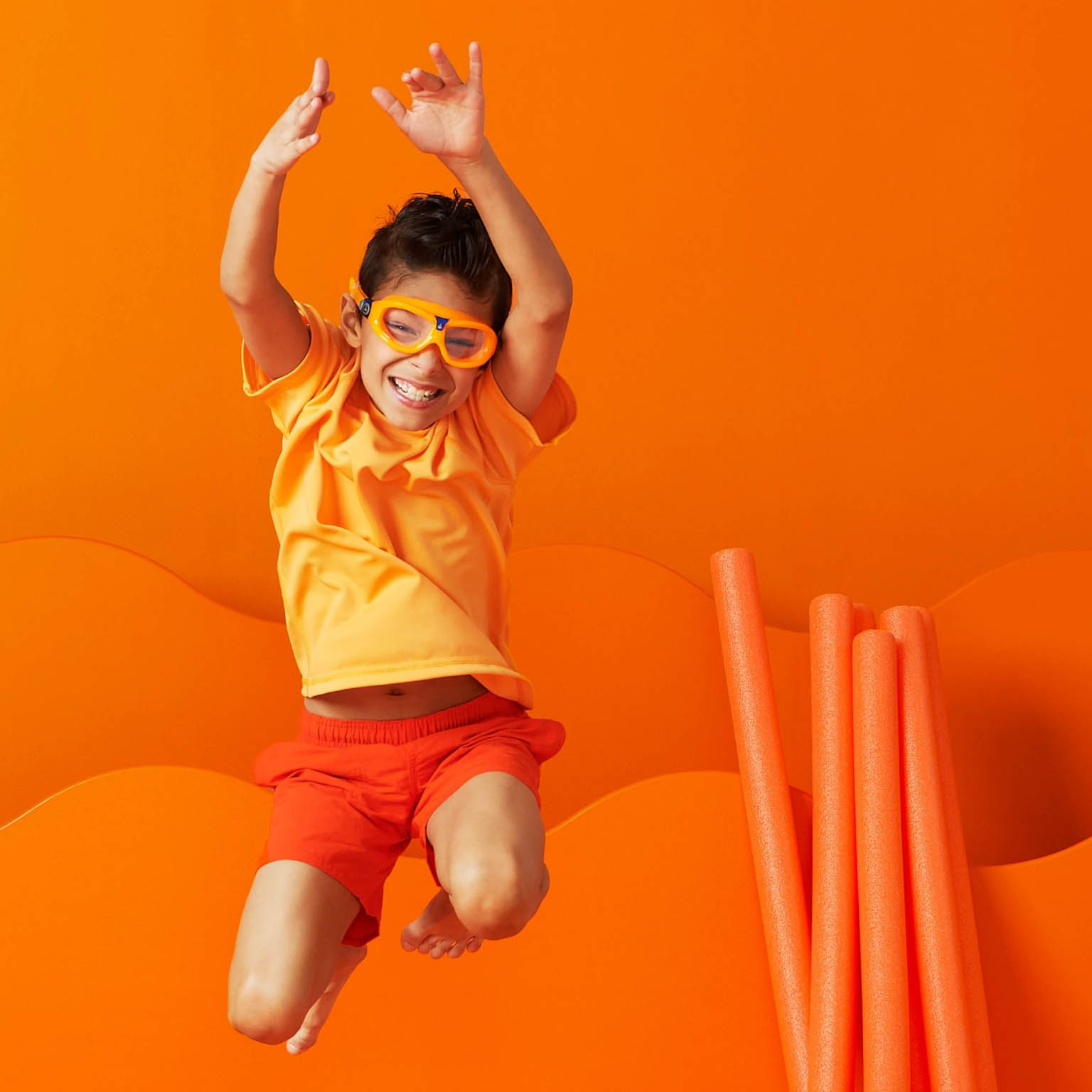 a boy in goggles jumping in excitement