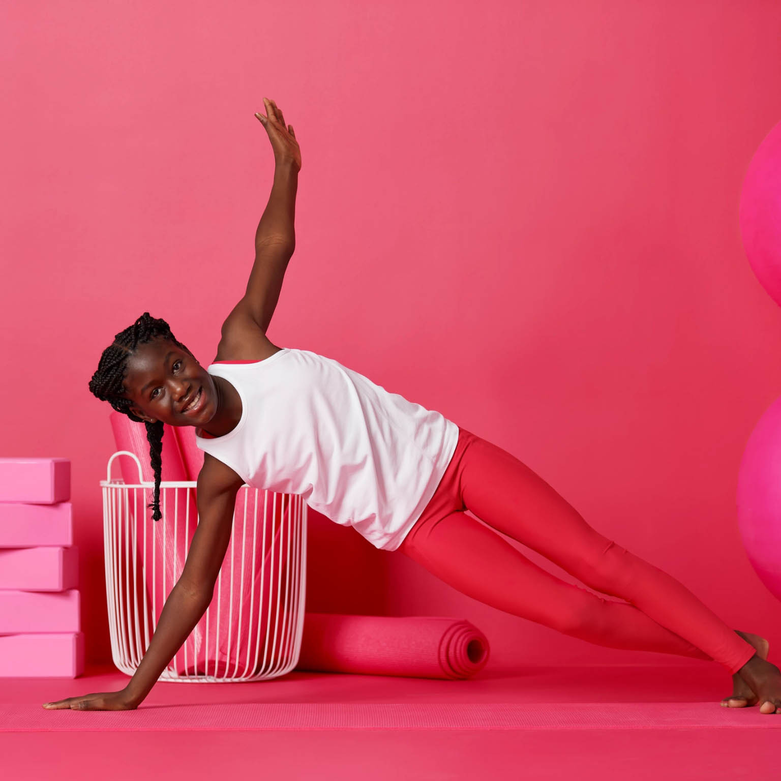 a girl practicing yoga with colorful mats, balls and blocks