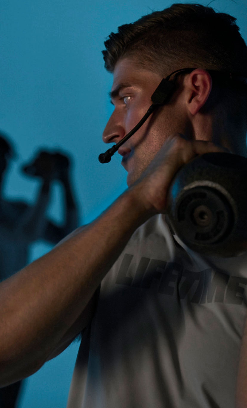 a male instructor leads a group fitness class