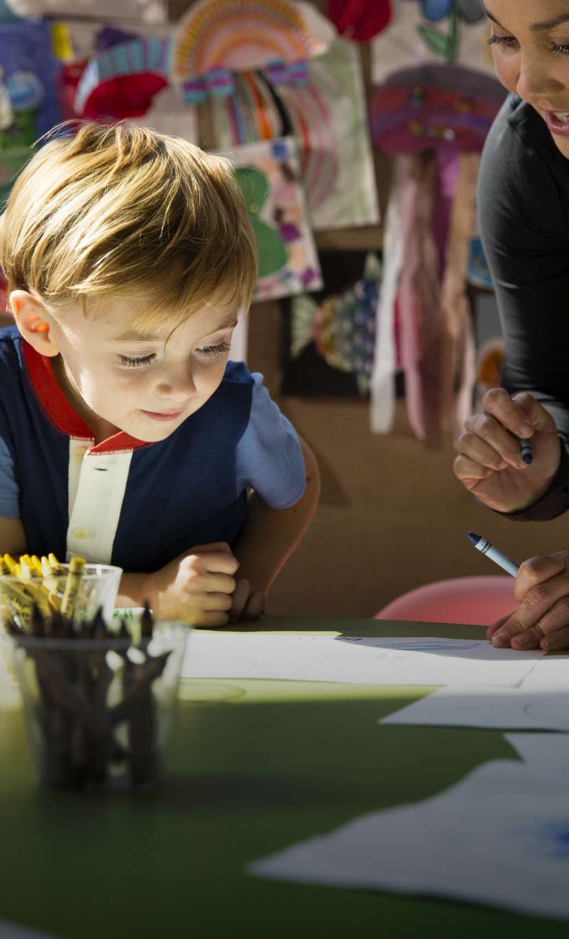 A child watches as an instructor explains an art project