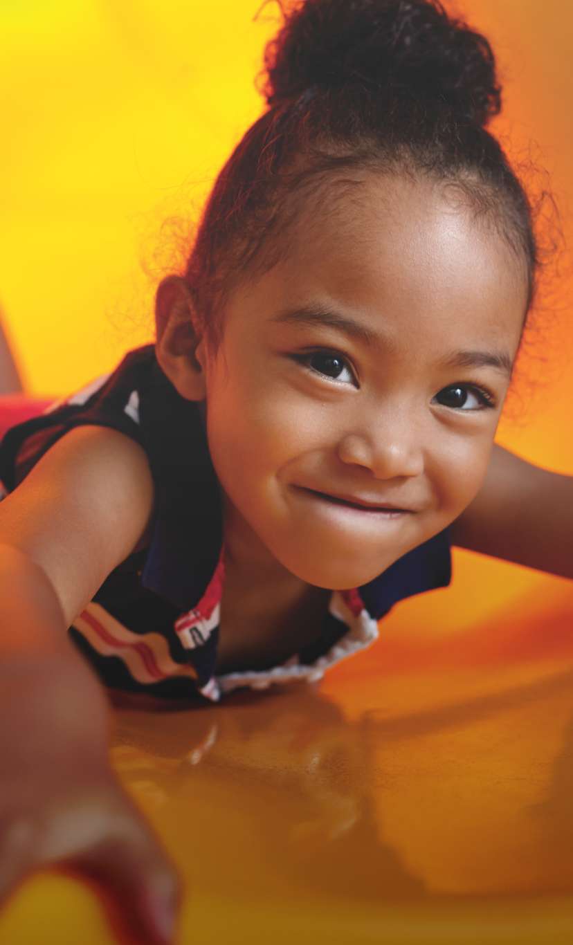 a girl slides down a slide head first