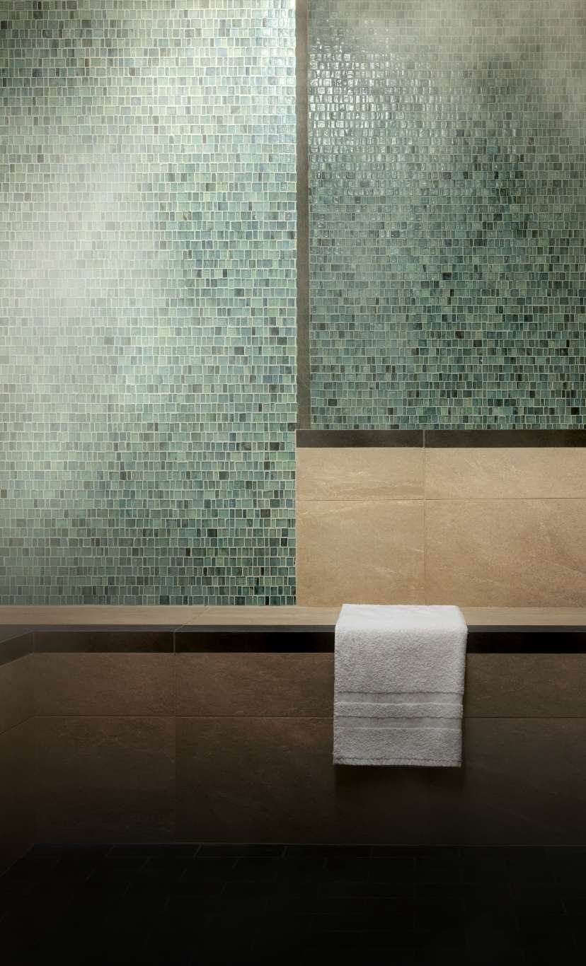 a white towel sits folded inside a luxurious steam room 