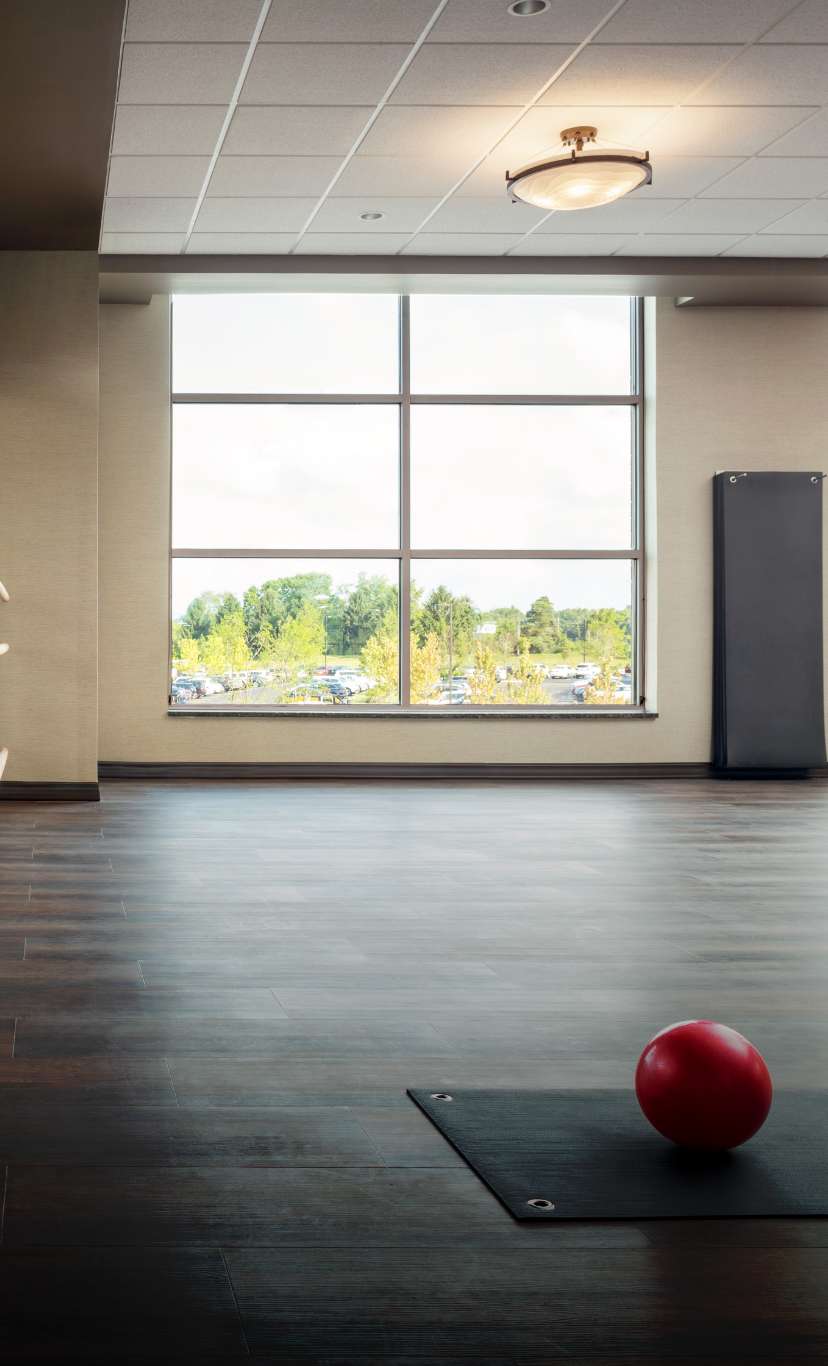 A yoga mat and medicine ball in an open studio space