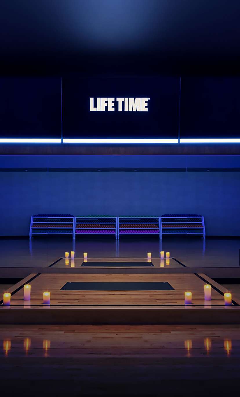 A dimly lit fitness studio with candles