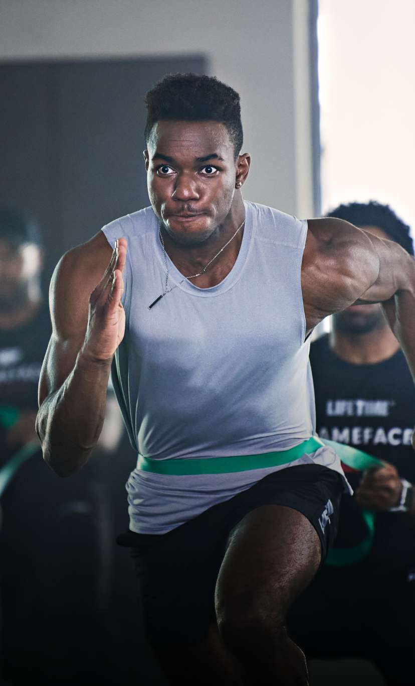 A man sprints while being held by a bungee cord