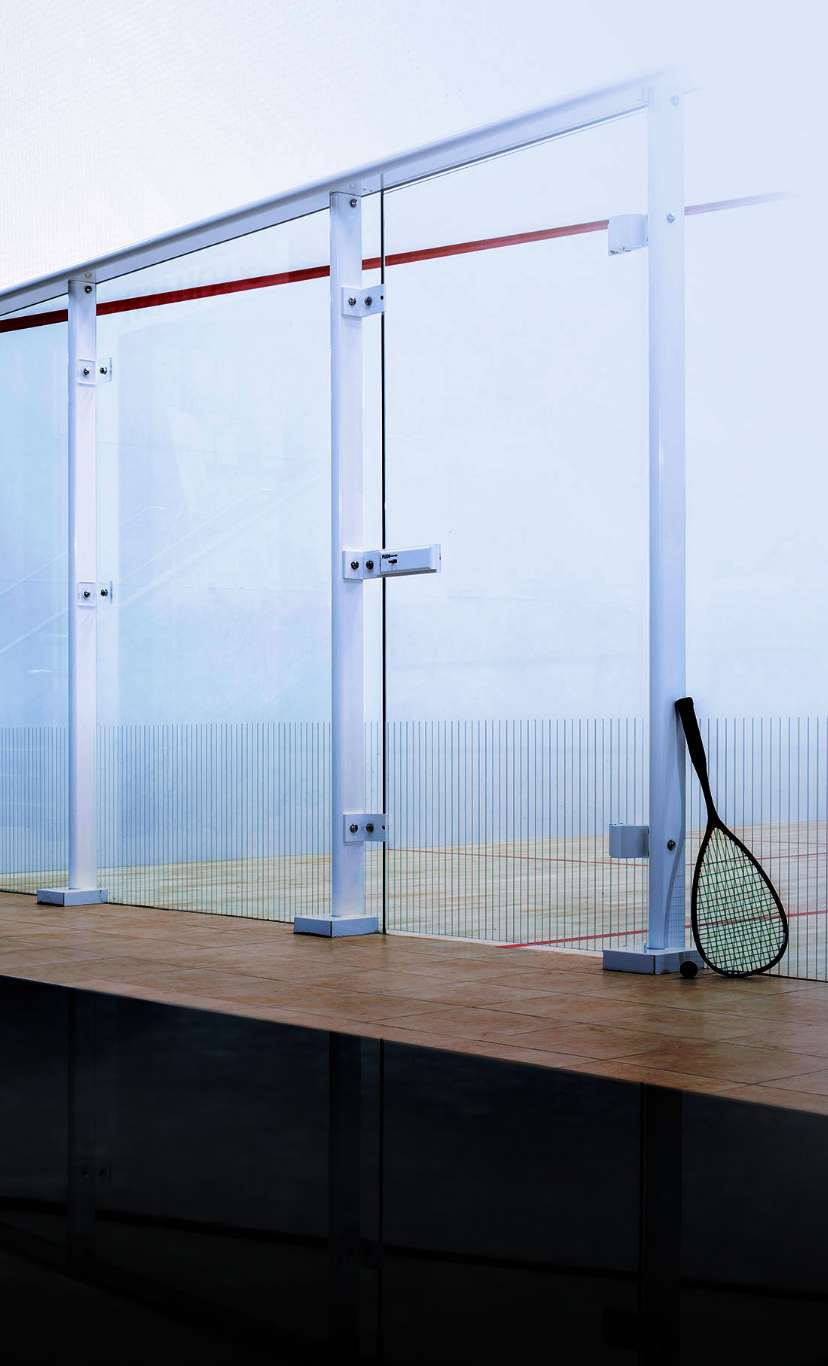 a racquet leans up against the glass of a racquet court