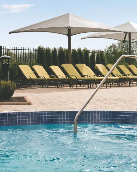 Row of pool deck chairs next to the outdoor leisure pool at Life Time