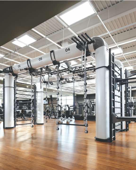 Expansive fitness floor with weight machines and racks of weights at Life Time