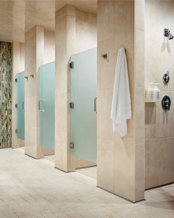 Row of locker room showers in a luxury locker room at Life Time