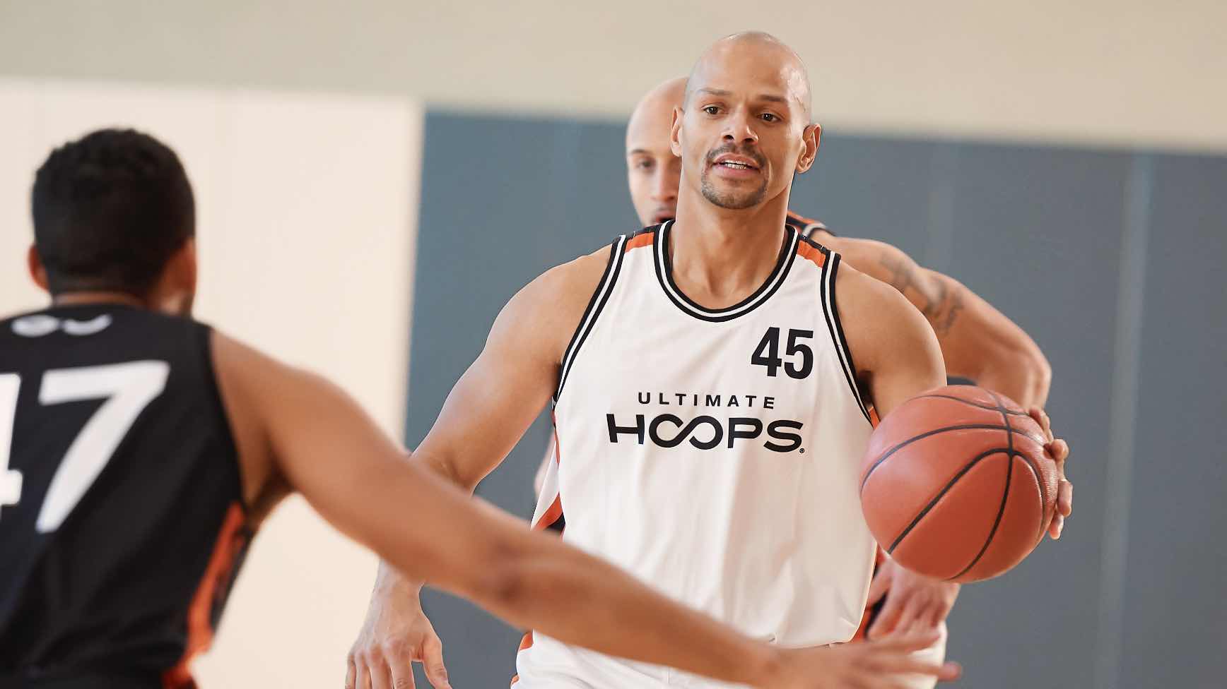 Three men playing game of basketball