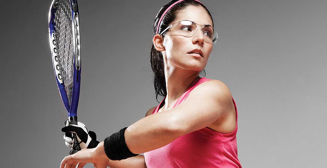 A woman on the racquetball court taking a swing