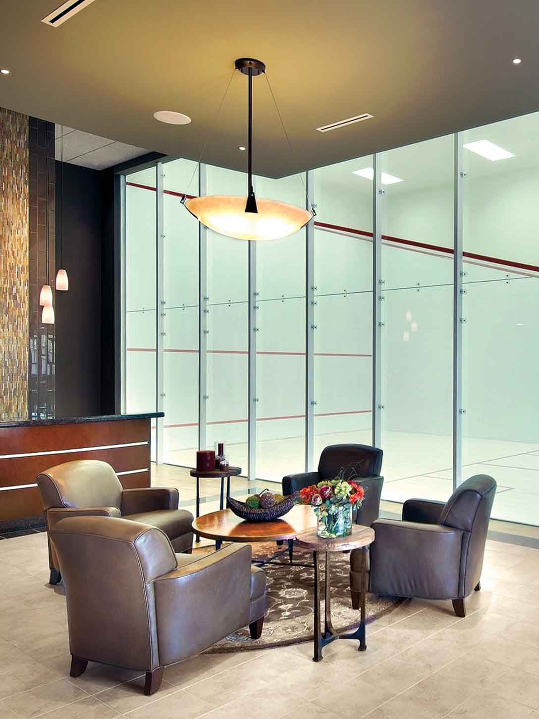 Comfortable chairs surrounding a table outside a Life Time squash court