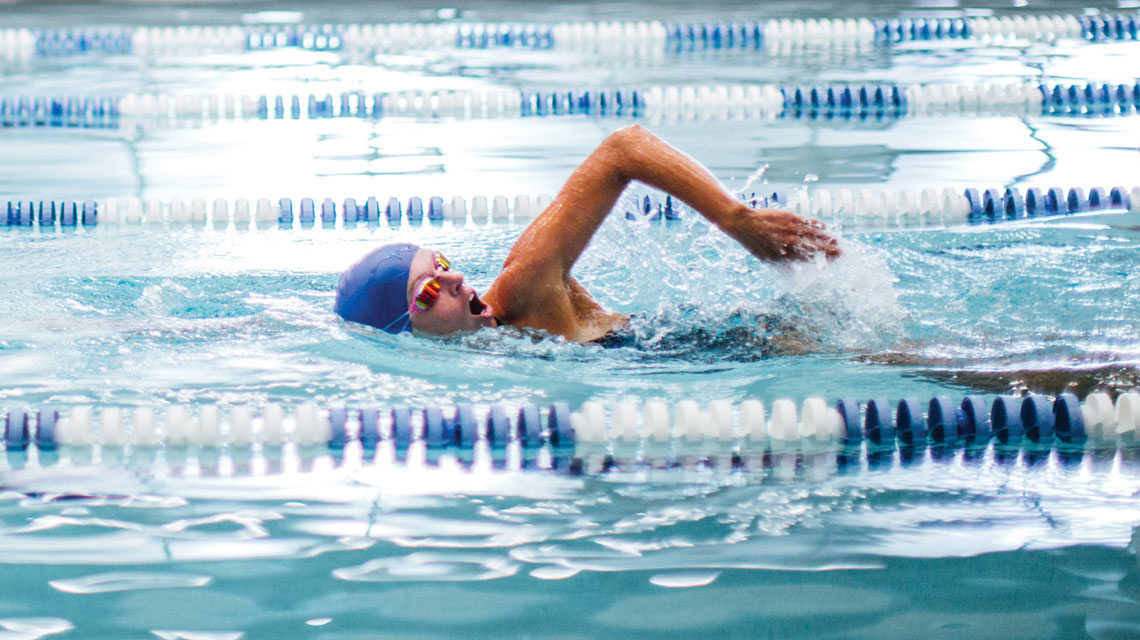Three girls in goggles swimming underwater