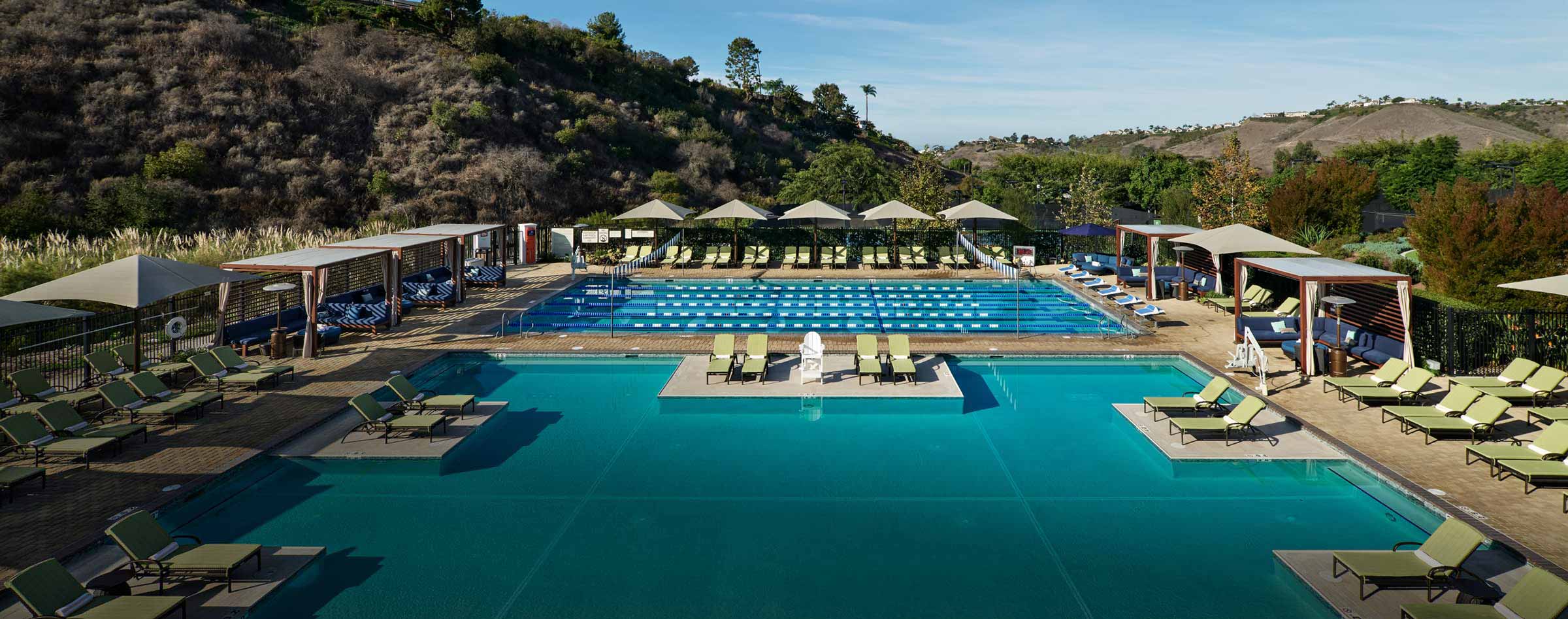 outdoor swimming pool and lap lane pool surrounded by lounge chairs