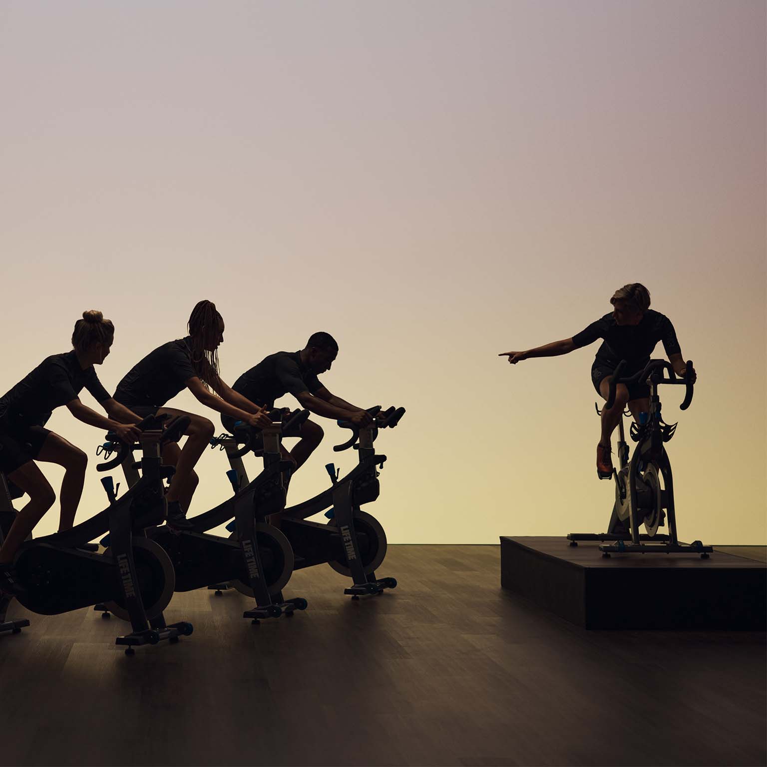 a group of people on stationary bikes in a cycle class