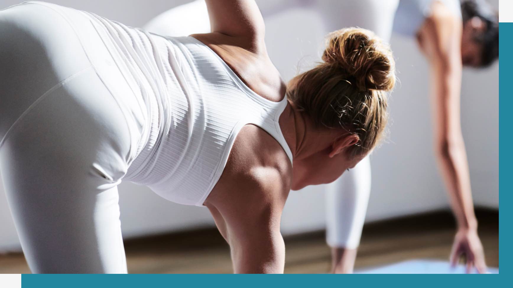 Two women holding yoga poses in a yoga studio at Life Time