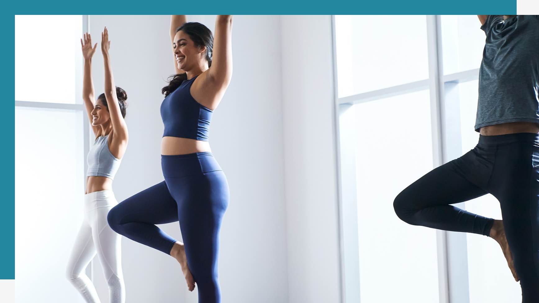 Three Life Time members holding yoga poses in a yoga studio at Life Time