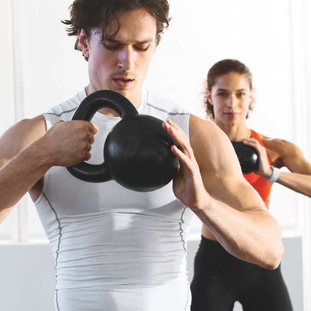Man using kettlebell in class