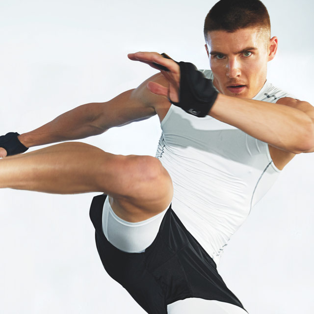 Man doing a high kick in class